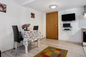 Un comedor con una mesa con sillas y un televisor. en Bäckerhus - Ferienwohnung 2, en Wiek auf Rügen