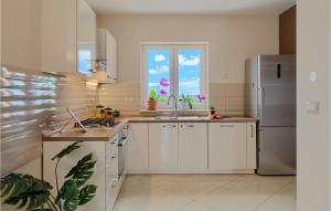 een keuken met witte kasten, een gootsteen en een raam bij Villa Pilati in Poreč