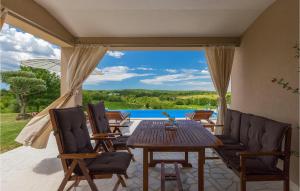 een terras met een tafel en stoelen en een zwembad bij Villa Pilati in Poreč
