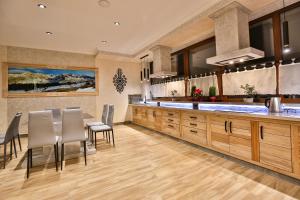 a kitchen with wooden cabinets and a table and chairs at Willa Śwarna I in Zakopane