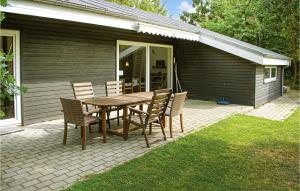 a wooden table and chairs on a patio at Holiday Home Eneb in Dagstrup