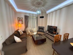 a living room with a couch and a television at Fani's Home No 14 in Tríkala