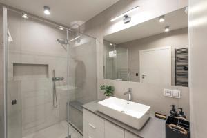 a bathroom with a sink and a shower and a mirror at Aparts4U - Kras Resort Apartament A103 z prywatnym jacuzzi i widokiem na góry in Szklarska Poręba +12 photos