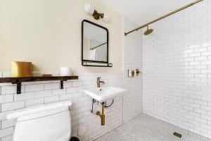 a white bathroom with a sink and a toilet at Jefferson Hotel in Miami +37 photos