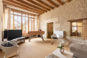 a living room with a couch and a pool table at Gîte La Belle Aventure avec piscine et jacuzzi in Mosnes