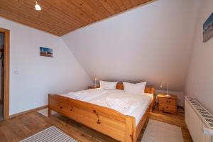 a bedroom with a wooden bed in a room at Ackerweg, App 01 in Ueckeritz +4 photos