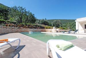 ein Swimmingpool mit zwei Stühlen und einem Tisch in der Unterkunft Villa Maremonti in Santa Lucia