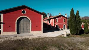 a red building and a red house with a fire hydrant at Cantina D'Erasmo - Camere e Degustazioni in Offida