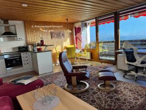 a living room with chairs and a table and a kitchen at 2-1 - Raum - Ferienappartements Dieter Hoffmann Freudenstadt-Kniebis beim Nationalpark in Freudenstadt