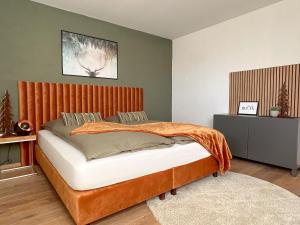 a bedroom with a bed with a wooden headboard at "SONNENGRÜN" - Premium Apartments Seekirchen, Balkon in Seekirchen am Wallersee