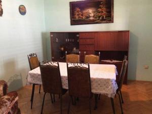 a dining room with a table and chairs and a painting at Apartments Sova in Postira