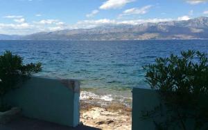 a view of a large body of water with mountains at Apartments Sova in Postira