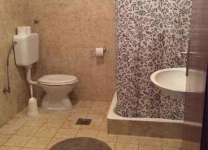 a bathroom with a toilet and a shower curtain at Apartments Sova in Postira