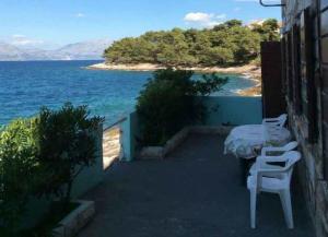 a patio with a table and chairs and the ocean at Apartments Sova in Postira