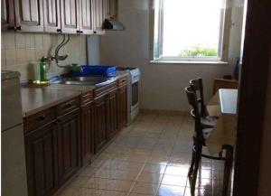 a kitchen with a sink and a stove and a window at Apartments Sova in Postira