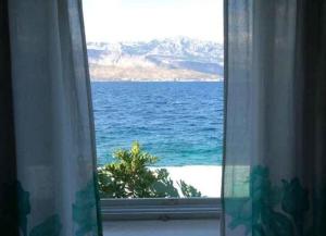 a view of the ocean from a window at Apartments Sova in Postira
