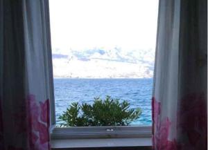 a window with a view of the ocean at Apartments Sova in Postira