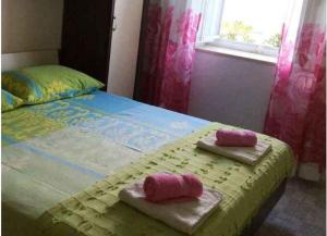 a bedroom with a bed with two towels on it at Apartments Sova in Postira