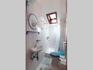a bathroom with a sink toilet and a mirror at Apartments Matej in Bol +30 photos