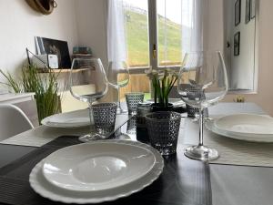 ein Tisch mit Tellern und Weingläsern darauf in der Unterkunft Snow 39 in Candanchú