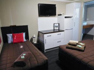 a small room with two beds and a tv at Narrabri Motel and Caravan Park in Narrabri