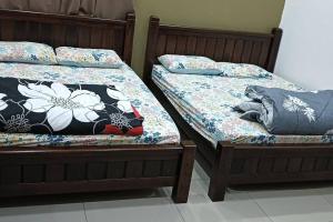 two beds sitting next to each other in a room at RALI PD HOME D 16Pax karaoke and swimming pool in Port Dickson +22 photos