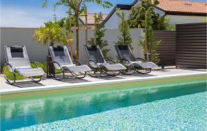 a group of chairs sitting next to a swimming pool at Villa Tina in Privlaka