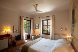 a bedroom with a bed and a tv and a window at La Almunia del Valle in Monachil +96 photos