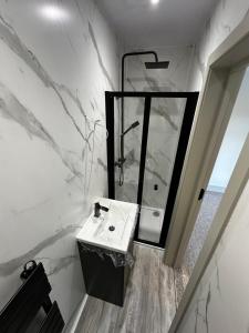 a white bathroom with a sink and a mirror at Abbey House in Waltham Abbey