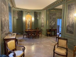 a dining room with green walls and a table and chairs at Appartement dans château in Limay