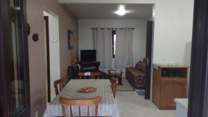 a dining table and chairs in a living room at Apartamentos Di Armazzem in Torres