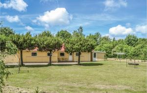 a yellow house with trees in the yard at Three-Bedroom Holiday Home In Oksbol in Oksbøl