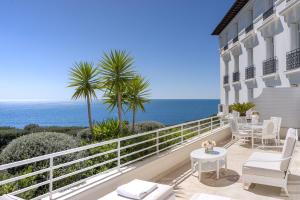 a balcony with a table and chairs and the ocean at Grand-Hôtel du Cap-Ferrat, A Four Seasons Hotel in Saint-Jean-Cap-Ferrat