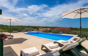 a swimming pool with chairs and an umbrella at Villa Marika in Lašći