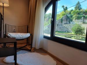 une chambre avec une fenêtre avec un lit et une table dans l'établissement Argento Inn, à Ioannina