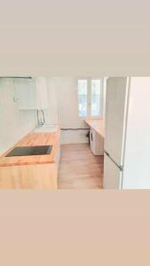 una cucina con frigorifero bianco e pavimenti in legno di Cosy a Canet-en-Roussillon