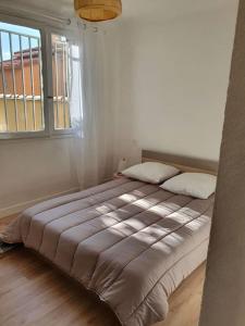 un letto grande in una stanza con una finestra di Cosy a Canet-en-Roussillon