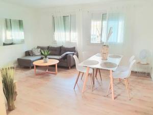 un soggiorno con tavolo, sedie e divano di Cosy a Canet-en-Roussillon Altre 15 foto