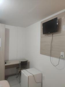 una habitación con TV colgada de una pared en Melquiades Hotel, en Patos