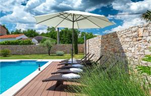 a group of chairs with an umbrella next to a pool at Villa Nada in Ružići