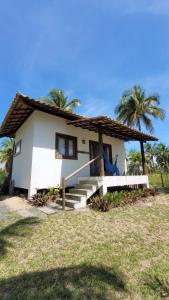 a small white house with stairs and palm trees at Karabebae bungalows Remo in Marau