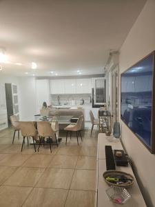 a kitchen and living room with a table and chairs at Emmanuel INN 1 in Drancy