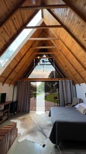 an attic bedroom with a bed and a large window at Cabanas Bela Vista in Rolante