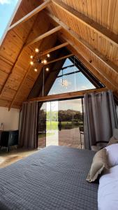 a bedroom with a large window and a bed at Cabanas Bela Vista in Rolante