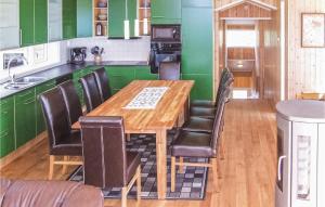 Øvre RamseにあるHoliday Home Dølemo Hillastadheiaのキッチン(緑のキャビネット、木製テーブル、椅子付)
