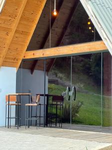 a glass extension to a house with chairs and tables at Cabanas Bela Vista in Rolante