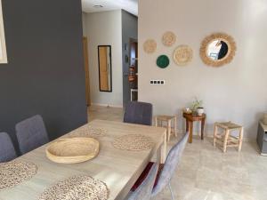 a dining room with a table and chairs and mirrors at APPARTEMENT BORDURE PLAGE in Kenitra