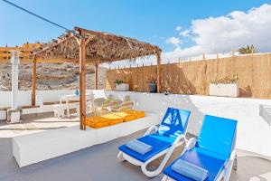 a patio with two blue chairs and a table at Traditional Canary beach house in Poris de Abona