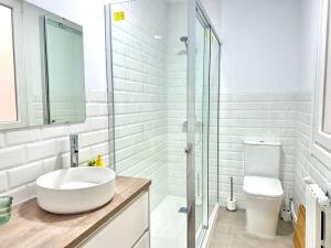 Un baño blanco con lavabo e inodoro. en Olivo, en Ferrol