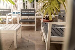 a group of white chairs and tables and a potted plant at Mont Vernon Villas in Cul de Sac